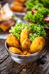 Chicken nuggets with salad in a metal bowl on a rustic wooden surface