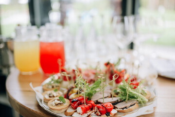 Treats for guests, various delicious canapes, sandwiches and drinks. Conceptual photo of a banquet.