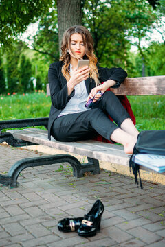 Office worker business woman working and holding online meetings in the park outside. Safe workplace outdoor, safe work space for the post-pandemic era