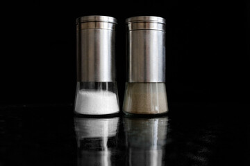 Salt and pepper shaker on black background