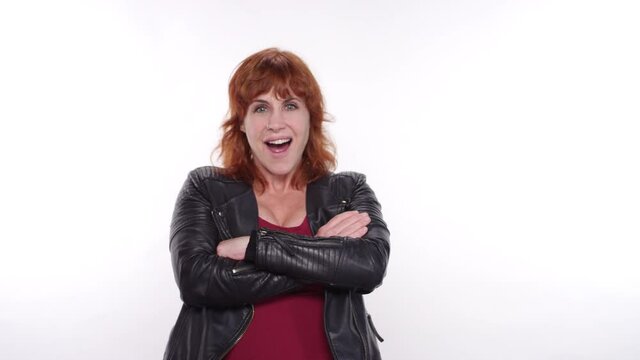Punk caucasian woman gets very excited and crosses her arms on a white studio backdrop
