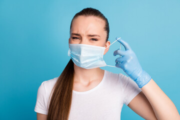 Closeup photo of beautiful but displeased lady bad mood hate always use facial respirators sensitive skin wear latex gloves protect face mask white t-shirt isolated blue color background