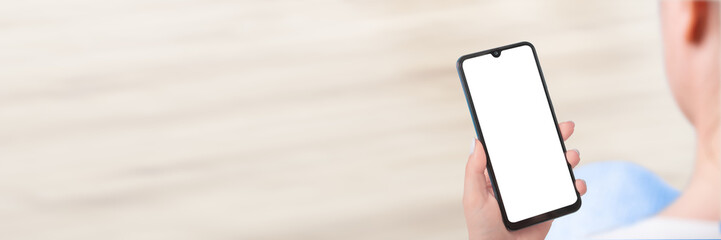 Woman's Hand Holding cell Phone With Blank Screen. Woman sitting and holding white screen mockup...