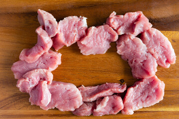 Fresh sliced raw pork on wooded cutting board.
