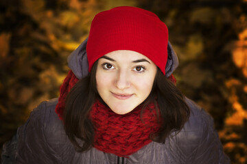 Girl in a red hat on a background of autumn yellow landscape.