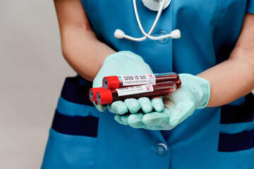 medical doctor nurse woman wearing protective mask and gloves - holding virus blood test tube