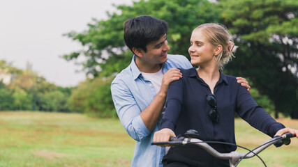 Obraz premium young couple riding a bicycle in the park.