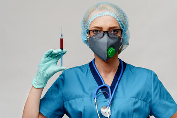 medical doctor nurse woman wearing protective mask and gloves - holding syringe