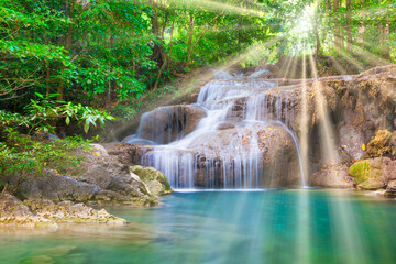 Tropical landscape with beautiful waterfall, wild rainforest with green foliage and flowing water. Erawan National park, Thailand