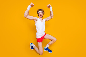 Fototapeta na wymiar Full length body size view of nice funky successful cheerful cheery crazy motivated guy standing on knee showing muscles isolated over bright vivid shine vibrant yellow color background
