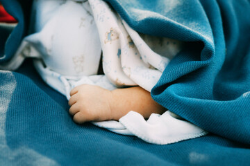 Close up photo of a cute looking little hand of a sleeping newborn baby