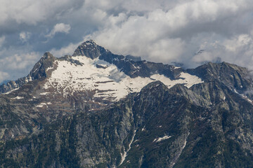 Fototapeta na wymiar peaks of Monte Zucchero and Triangolino in Ticino mountains, dark clouds