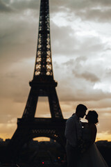 silhouette of lovers at sunset against the background of the Eiffel tower. The moment before the kiss. wedding in Paris