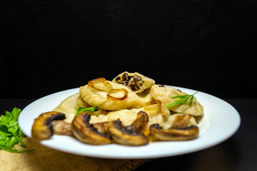 Dumplings with mushrooms, on a black background