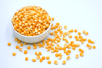 Corn kernels for making popcorn in white ceramic bowl.