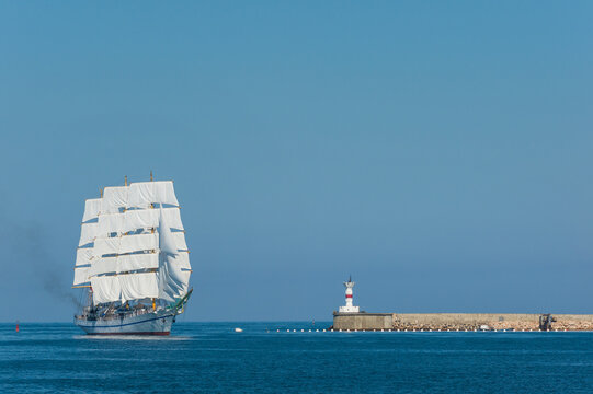 Beautiful three mast tall ship sailing past Fort Constantin lighthouse at the entrance to Sevastopol Bay, Crimea
