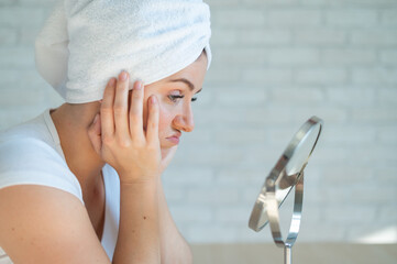 A sad woman sits at a table and looks in the mirror. A miscarriage of a girl with hormonal problems...