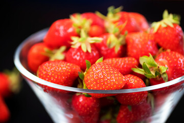 Fresh organic strawberries in a glass bowl.