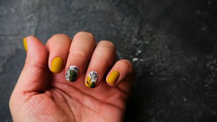 Women's hands with colorful patterns on the nails. 2020 colors trend. Top view. A place for text.