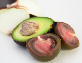 vegetables black tomatoes, avocado and onions on white background