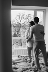 Selected soft focus on a window Stunning sensual intdoor portrait of young stylish fashion couple in love. Woman and man embrace and want to kiss each other. They are smiling and looking to each other