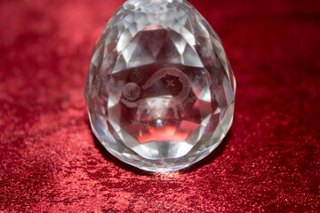 A glass egg with iridescent faces and inside the zodiac sign Scorpio.