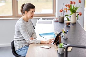 remote job, business and people concept - young woman with tablet pc computer working at home office and drinking coffee