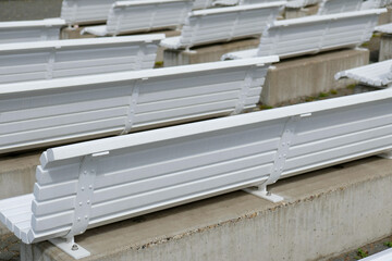 several empty white wooden benches