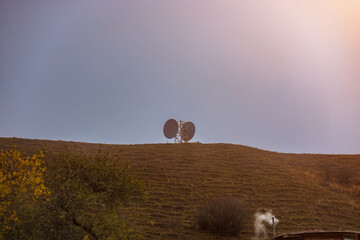 Two satellite dishes on the hill