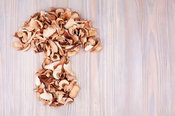 Edible dried mushrooms on light wooden background closeup top view, dry boletus edulis wood backdrop, brown cap boletus, penny bun, cep, porcino, porcini, white fungus, natural food design, copy space