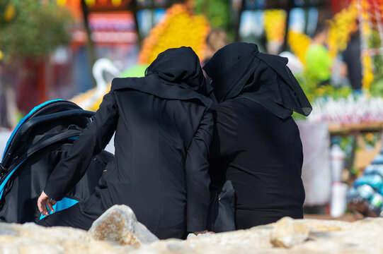 Two conservative women are sitting at the park