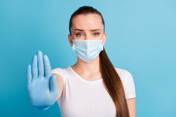 Closeup photo of pretty serious lady keep social distance avoid people contact hospital examination raise arm stand far away wear protect face mask t-shirt isolated blue color background