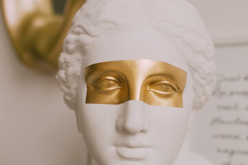 white plaster statue with gold stripe on the eyes