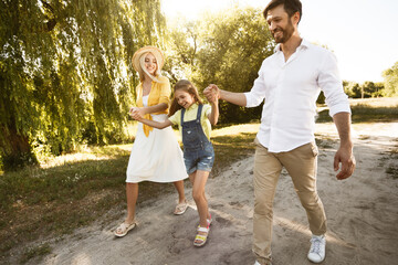 Family Going On Picnic Having Fun Walking Near Riverbank Outside