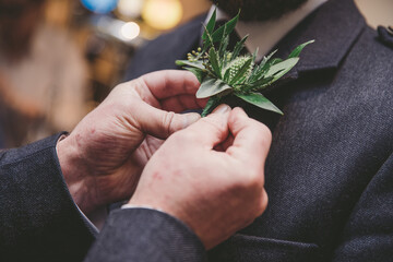 thistle corsage being pinned on to suit