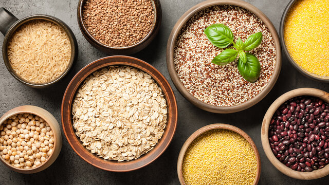 Set with various cereal grains and legumes on stone background