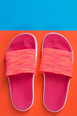 pink slippers on a blue and orange background, the concept of seasonal shopping and leisure