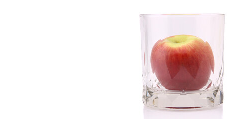 Apple in glass cup isolated on the white background in studio With copy space.