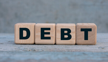 DEBT word on cubes on an old gray background .