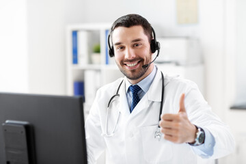 healthcare, medicine and technology concept - happy smiling male doctor with computer and headset...