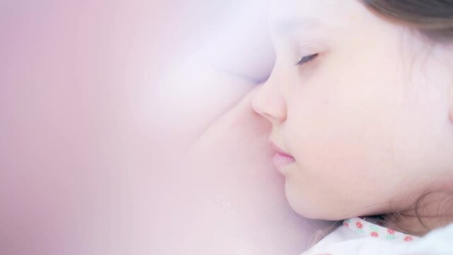 Close up portrait of cute brunette little girl sleeping in bright white bedroom alone. Beautiful sleepy kid have a nap, have eyes closed on white bed.