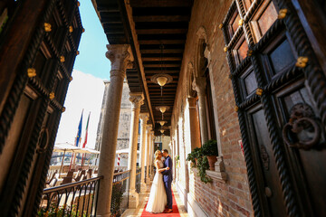 beautiful bride and handsome groom posing in streets of venice
