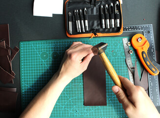 Repairing leather wallet in workshop