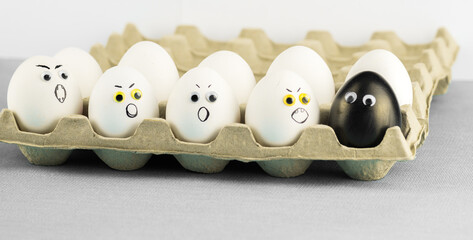 Black egg among angry racist xenophobic white eggs - abstract of anti - racism Black Lives Matter...
