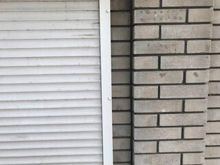 Fototapeta premium The background is two pieces, left plastic white rollettes on the right wall of white brick