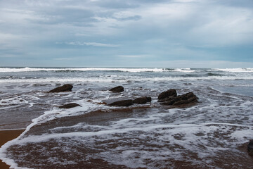 Landscape of water flooding the sand of a beach at the north of Spain