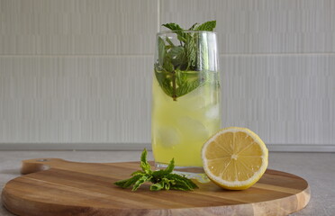 Cocktail with mint, ice and lemon on cutting board