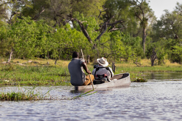 Canoeing  traditional Mokoro boats on the Khwai River in the Moremi Game Reserve Botswana