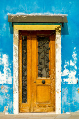 Old traditional door on colorful building at Burano island, Italy
