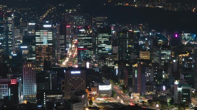 Arial timelapse flying over illuminated night Seoul city business district